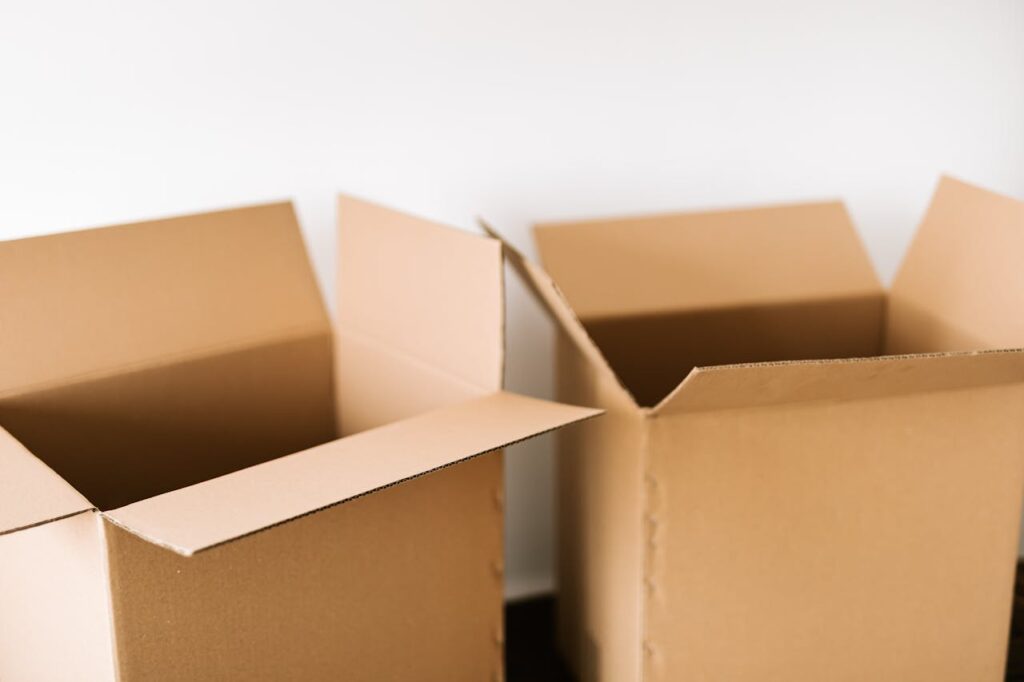 Cardboard boxes on dark surface against white wall
