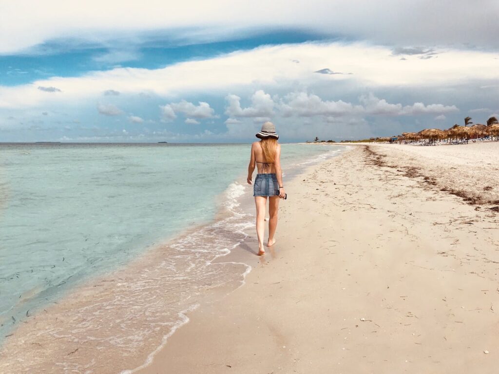 Back View Photo of Women Walking by the Beach