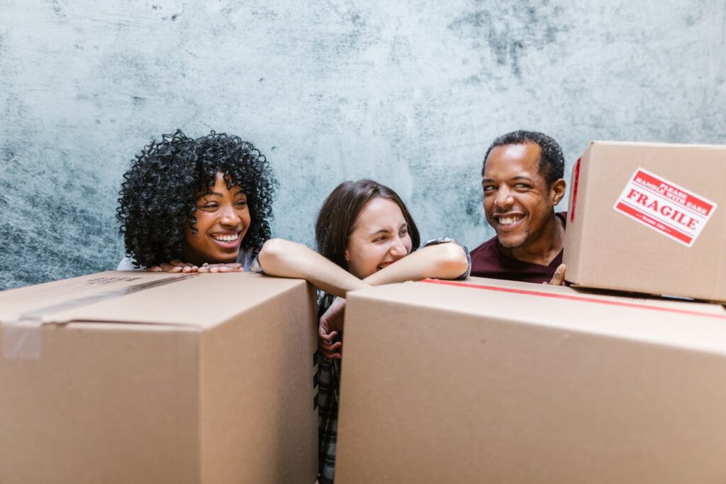 2 Women and Man Surrounded by Boxes after moving from Fayetteville to Charlotte