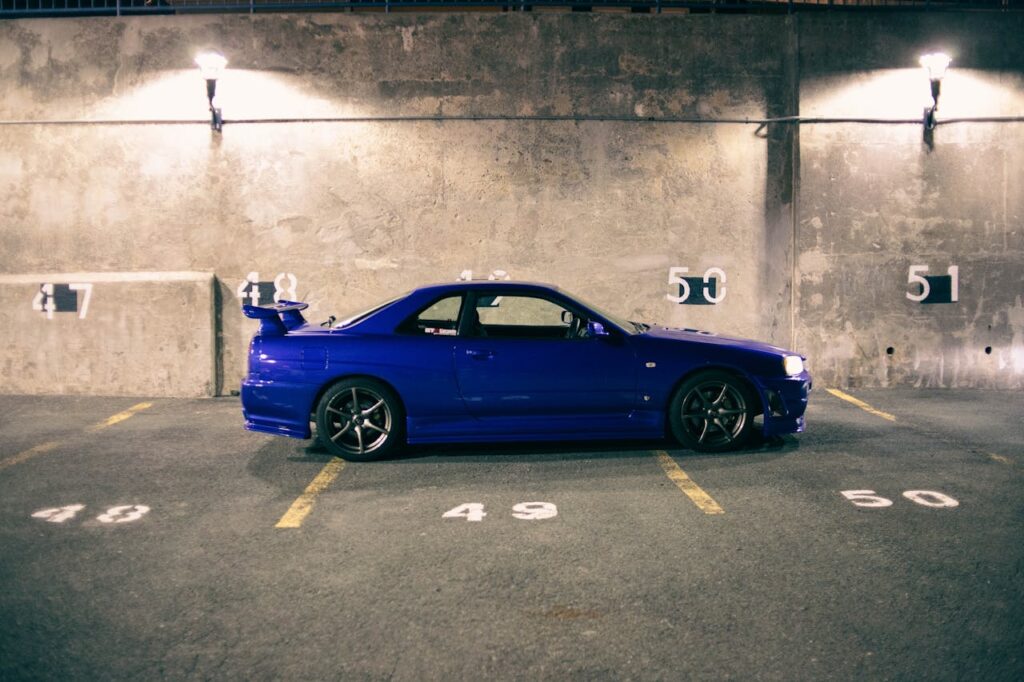 A Blue Car Parked Inside The Parking Lot